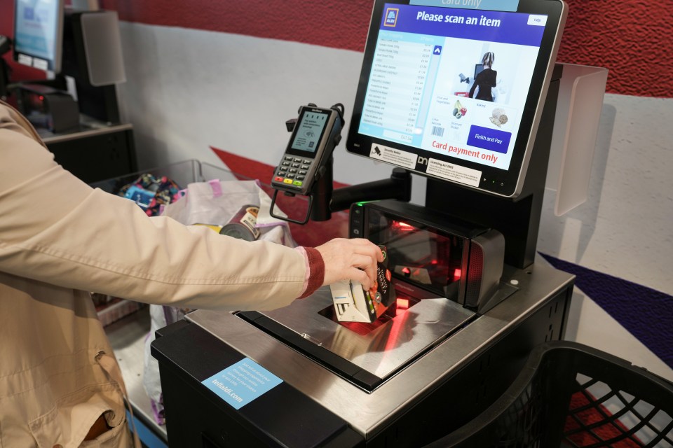 Customer using a self-checkout terminal at a supermarket.