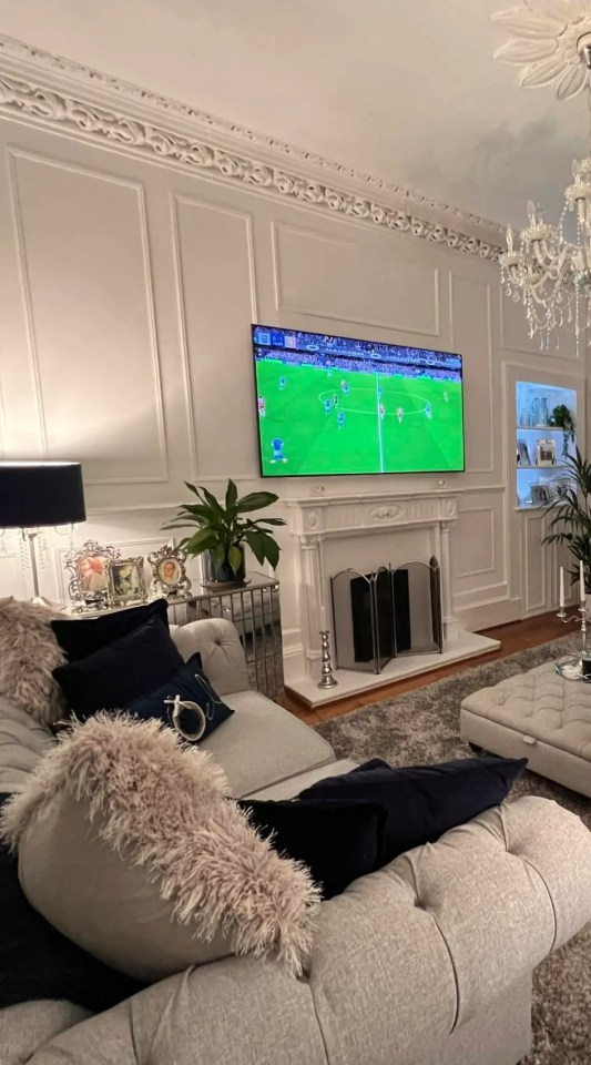 Living room makeover after water damage, featuring a large TV showing a soccer game.