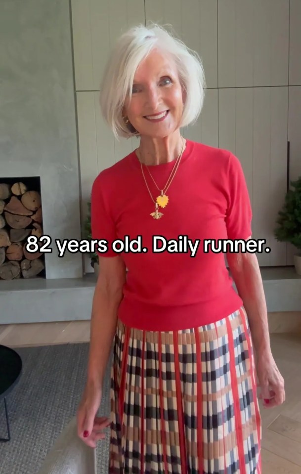 82-year-old woman in red top and plaid skirt.