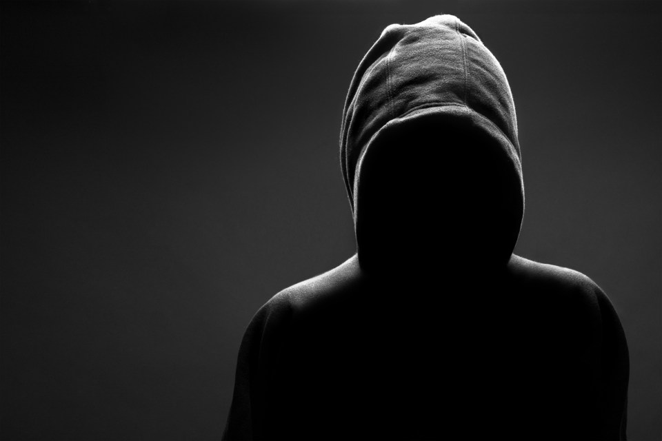 Silhouette of a person wearing a hoodie.