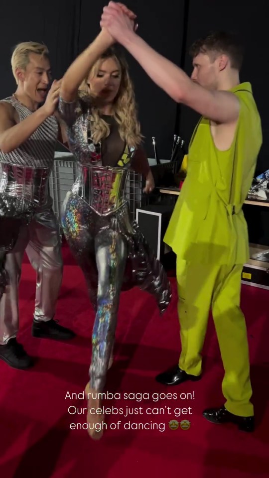 Three dancers high-five on a red carpet.