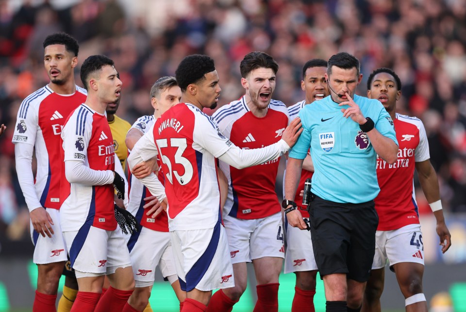 Arsenal players appealing to a referee after a red card.