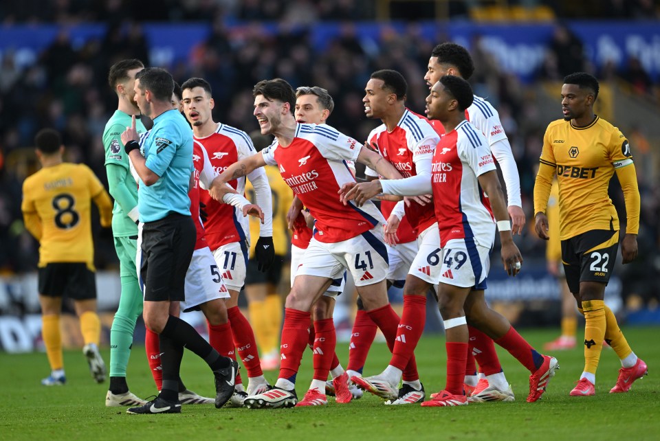 Arsenal players protesting a referee's decision.