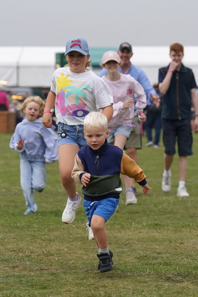 Children running on a grassy field.