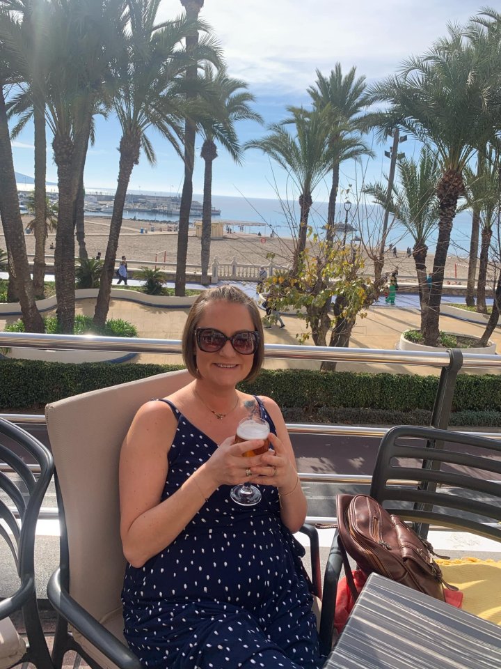 Woman in Benidorm, Spain, enjoying a drink outdoors.