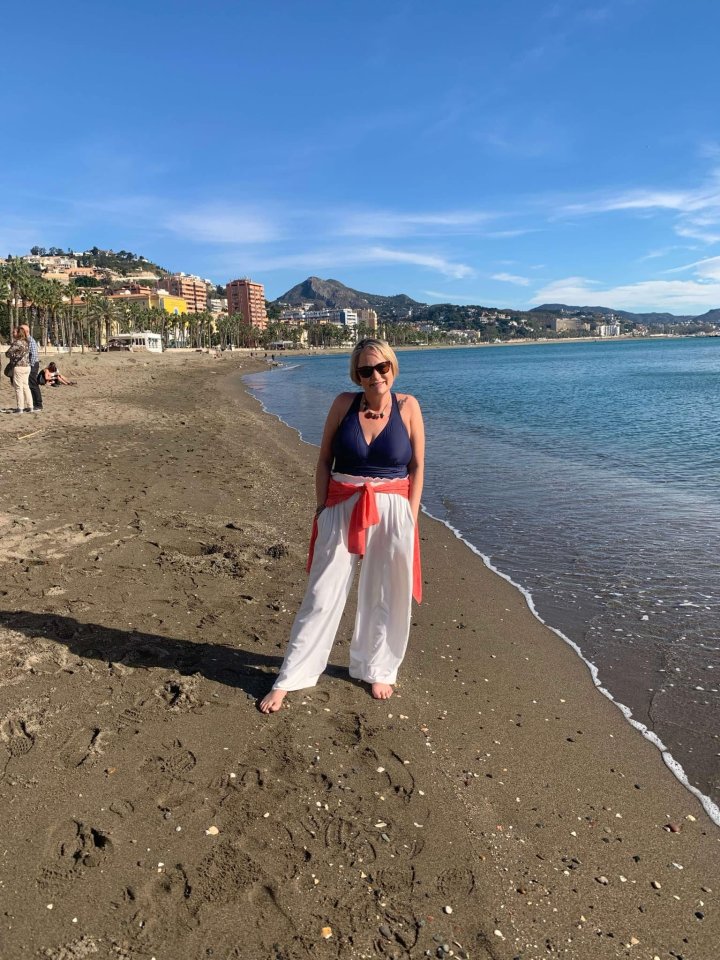 Woman standing on a beach in Malaga, Spain.