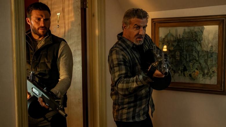 Still from Alarum, showing Scott Eastwood and Sylvester Stallone holding guns.