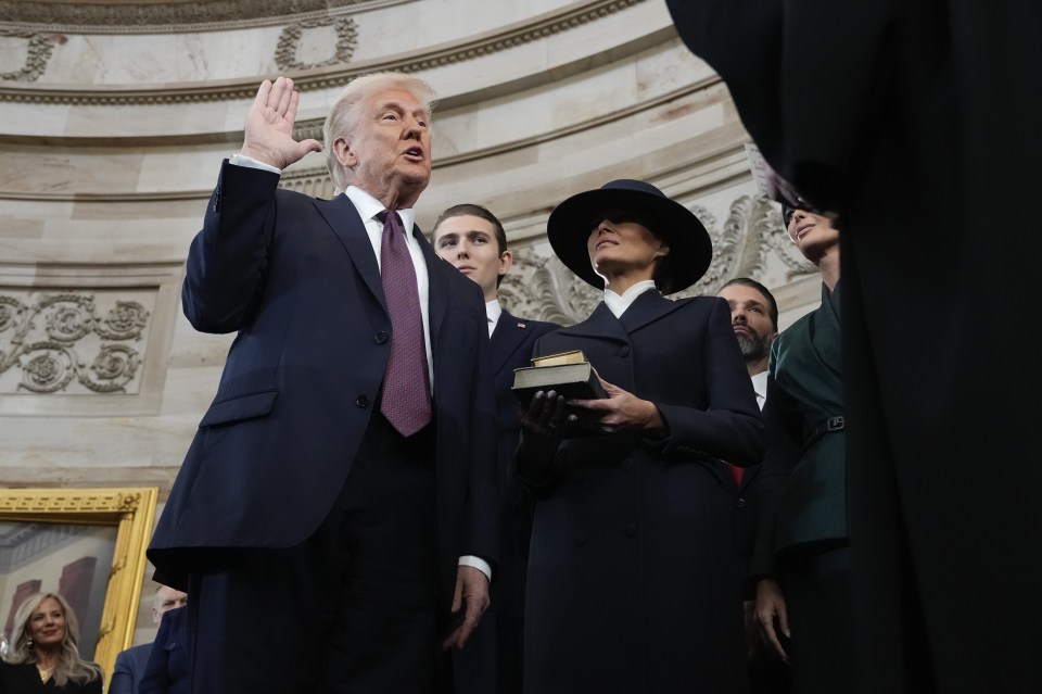 Donald Trump being sworn in as president, with Melania Trump holding a Bible.