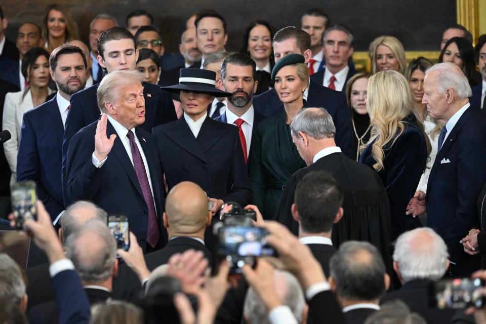 Donald Trump being sworn in as president, surrounded by family and onlookers.