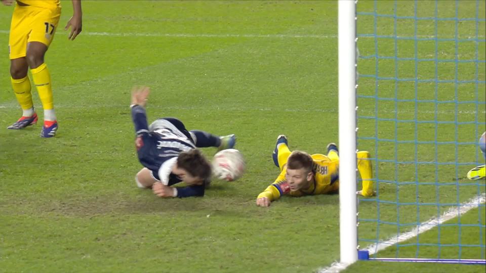 Soccer players diving for the ball near the goal.