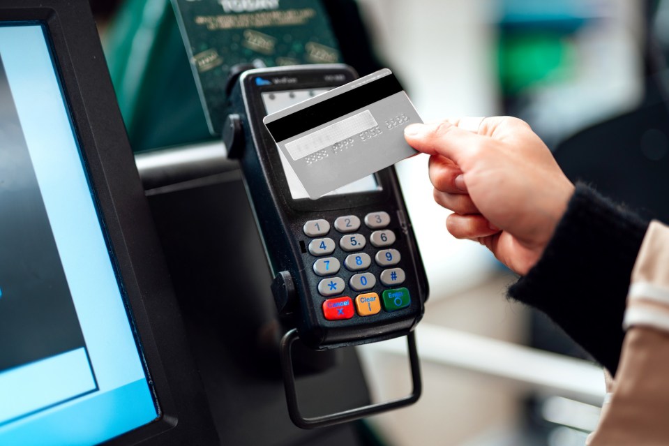 Close-up shot of a woman using contactless payment via credit card to pay for her shopping at self-checkout counter in a store