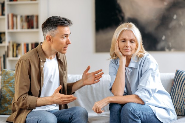 A couple arguing on a couch.