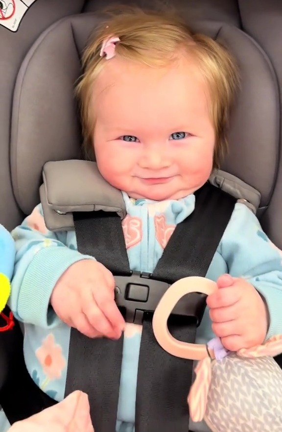 Smiling baby in a stroller.