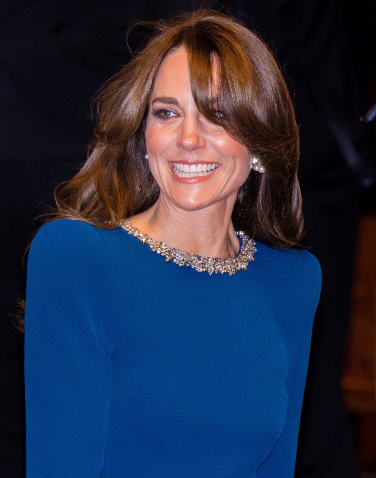 Catherine, Princess of Wales, smiling in a blue dress.