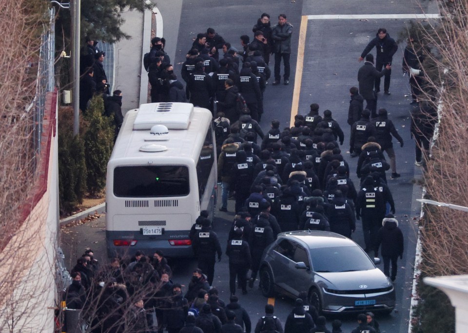 Police officers approaching a residence.