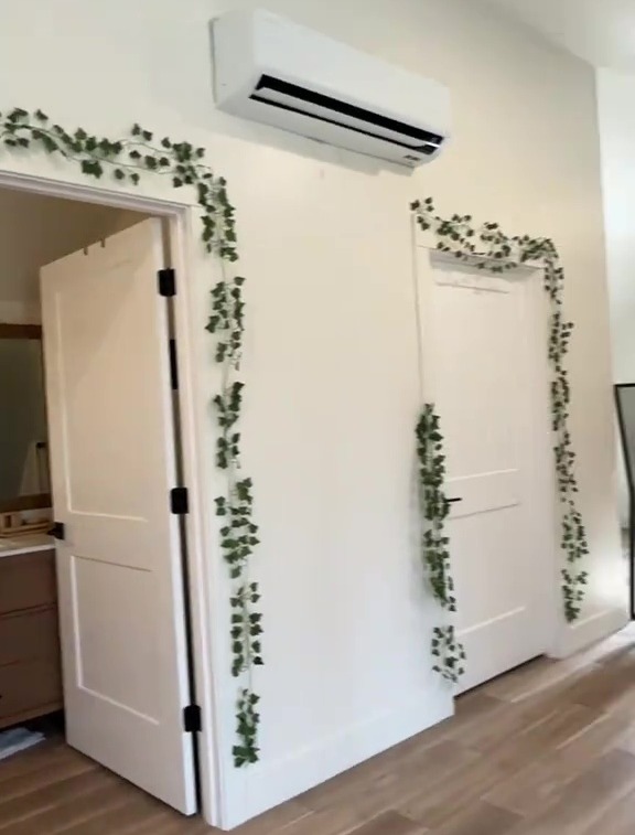 Interior of a room with white doors and faux ivy decor.