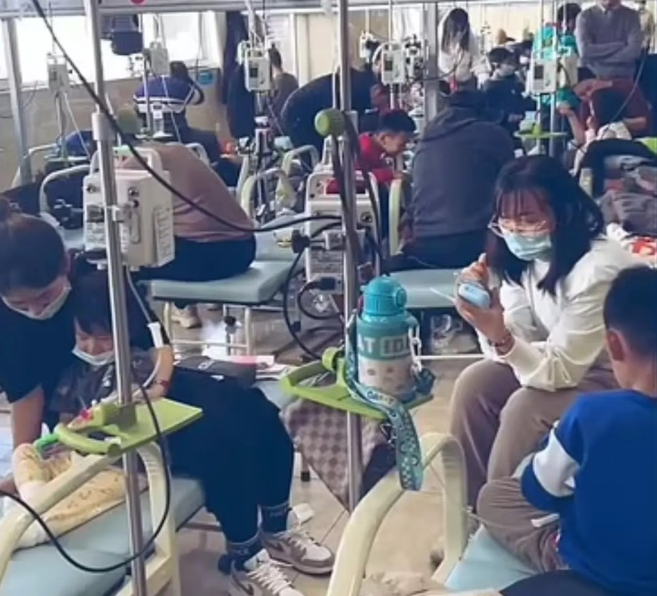 Overcrowded Chinese hospital ward with many patients receiving IV treatments.