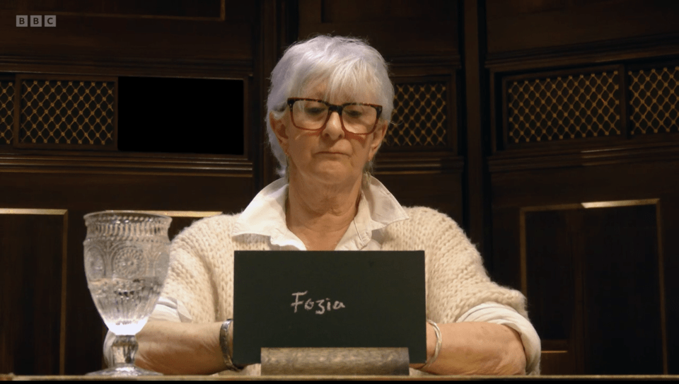 Linda from The Traitors holding a slate that says "Fozia".