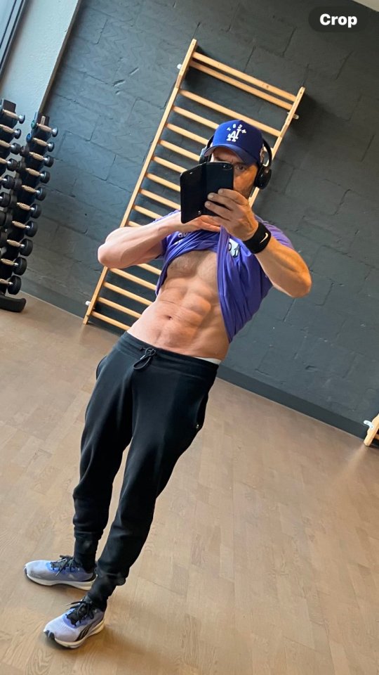 Man in gym showing off his abs.