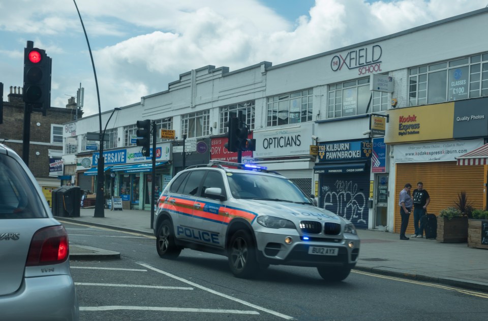 A police BMW X5 driving down a London street.