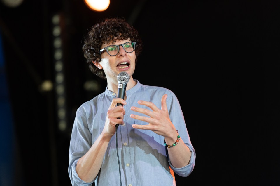 Simon Amstell speaking into a microphone at a festival.