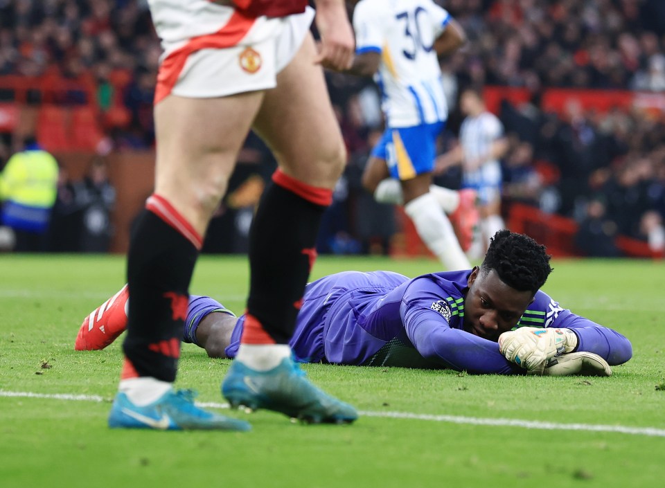 Andre Onana, Manchester United goalkeeper, lies dejected on the field.