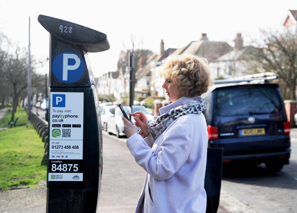 Woman using a mobile phone app to pay for parking.