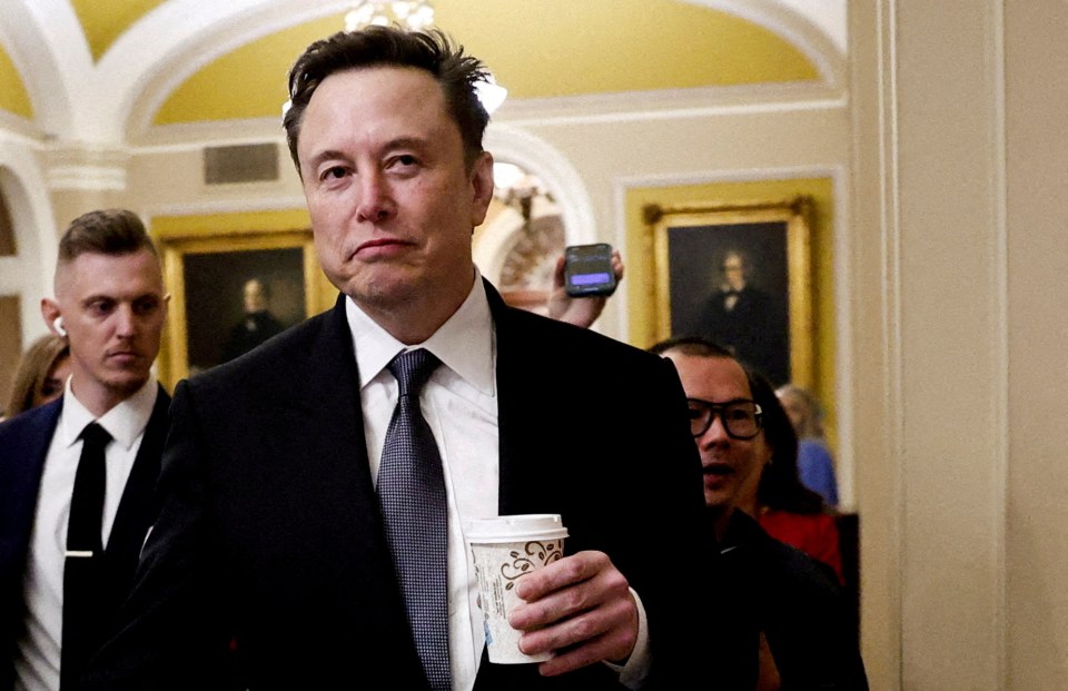 Elon Musk walking on Capitol Hill, holding a coffee cup.