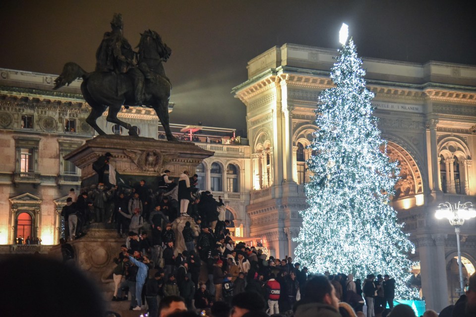 Crowd gathered around a large Christmas tree in Duomo Square, Milan.