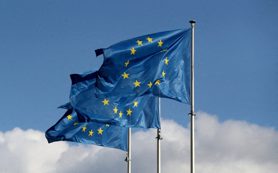 Three European Union flags waving in the wind.