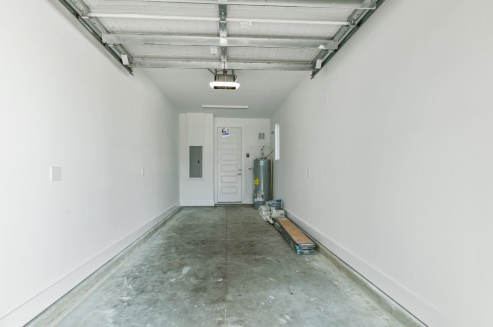 Empty garage with concrete floor and overhead door.