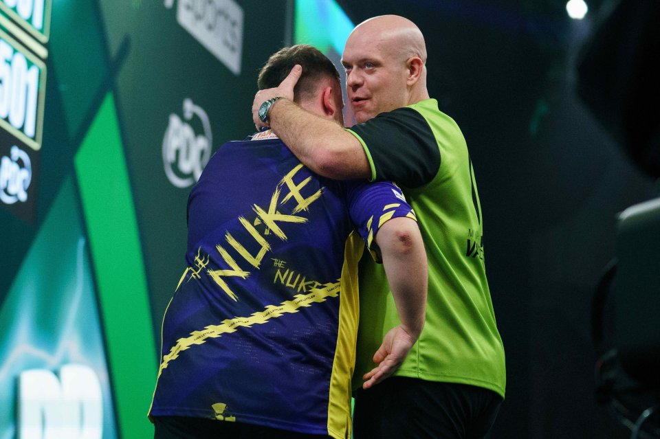 Michael van Gerwen congratulating Luke Littler after a darts match.