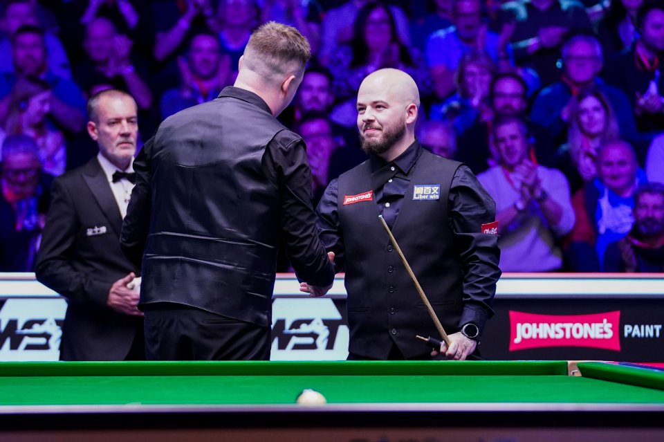 Kyren Wilson and Luca Brecel shaking hands after a snooker match.