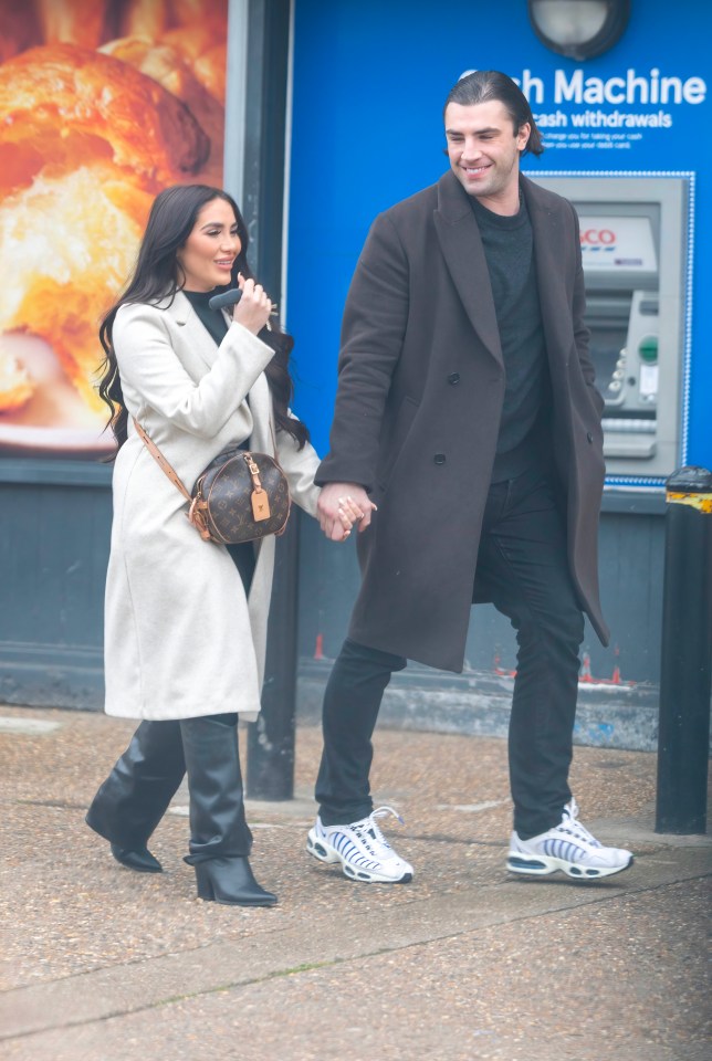 Jack Fincham and Chloe holding hands walking down the street.