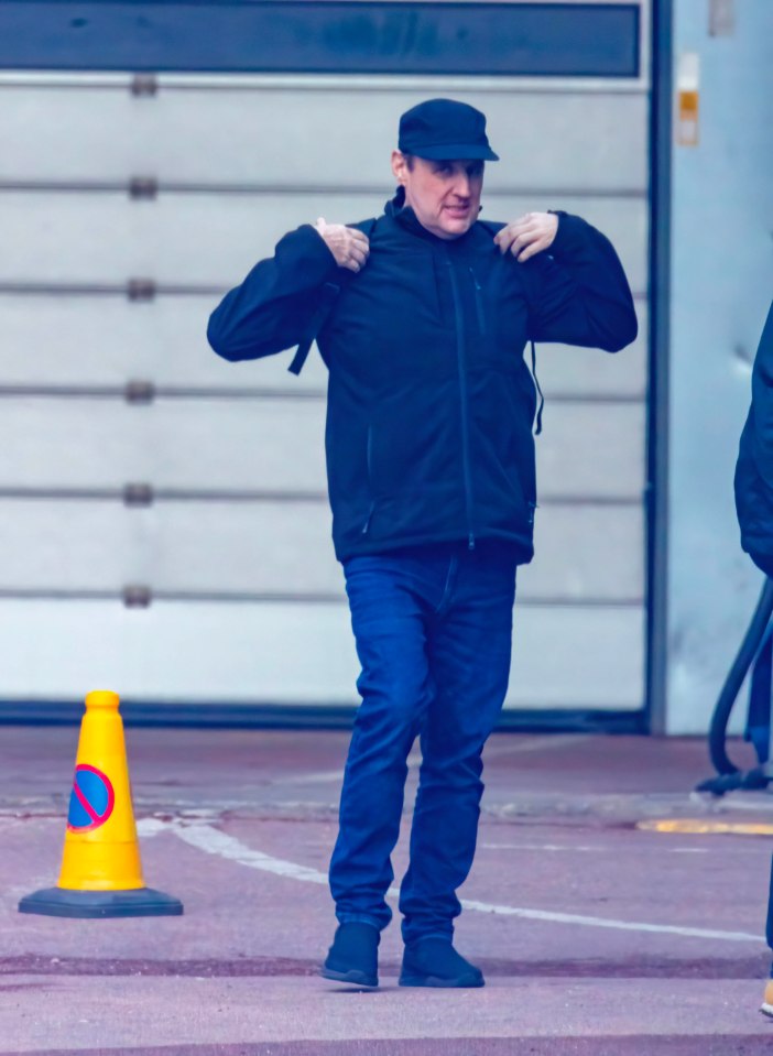 Peter Kay walking near a tour bus.