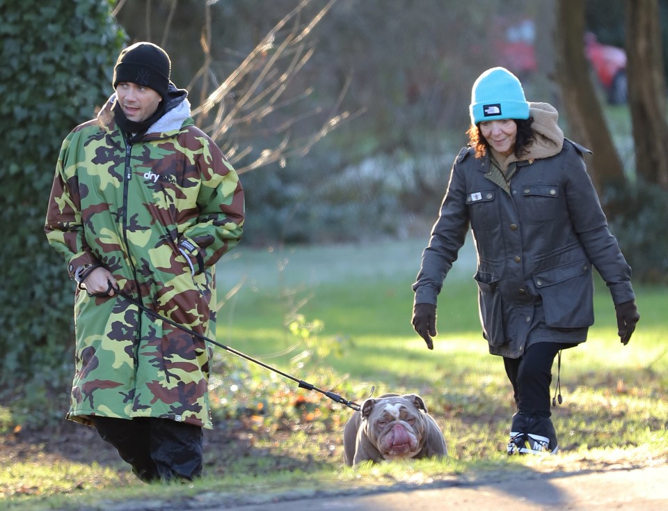 Max George walking his dog with his mother after a heart operation.