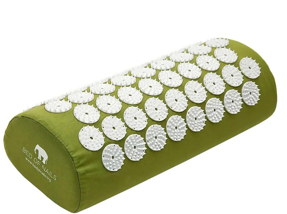 Green acupressure pillow with white plastic studs.