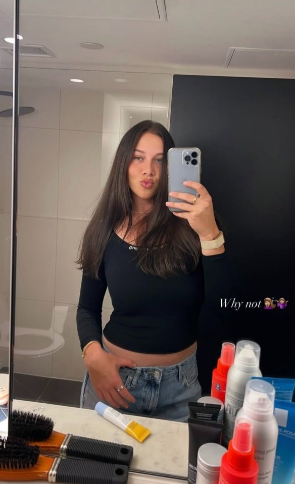 Woman taking a selfie in a bathroom.