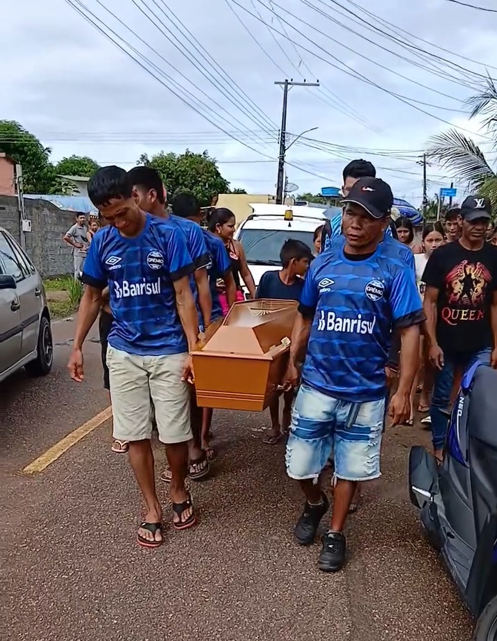 People carrying a coffin down a street.