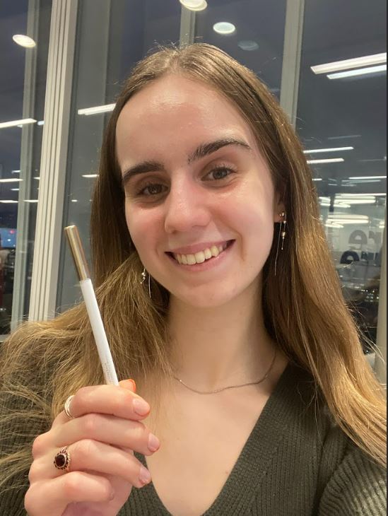 Woman holding Lisa Eldridge concealer.