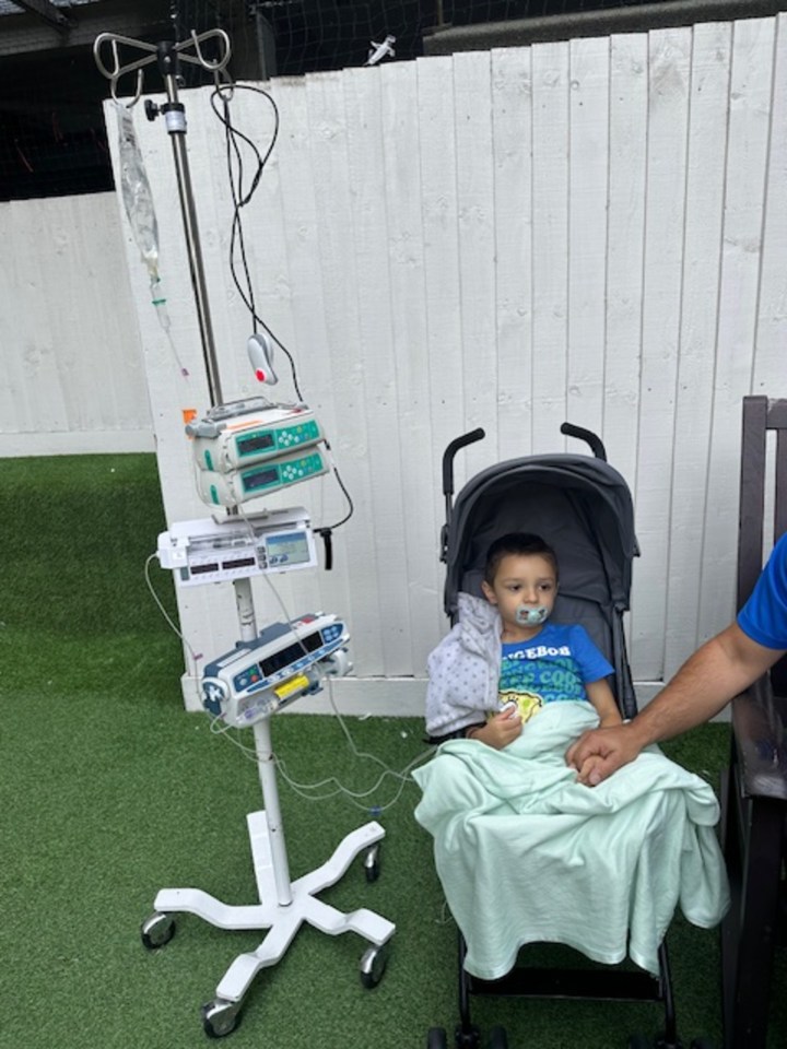 Young boy with leukaemia receiving medical treatment outdoors.