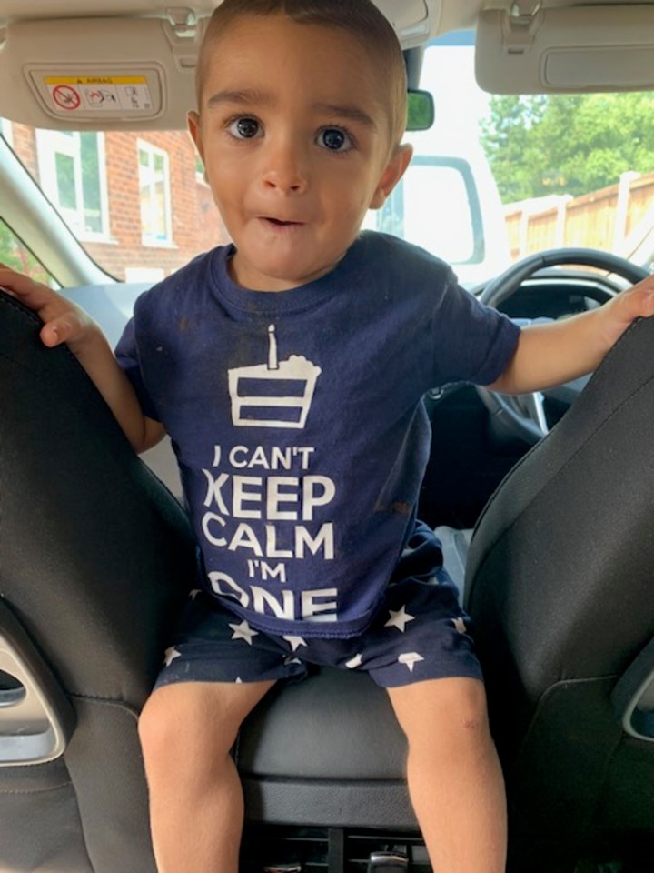 Toddler wearing an "I can't keep calm I'm one" t-shirt in a car.