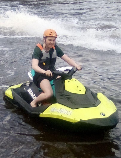 A young man riding a jet ski.