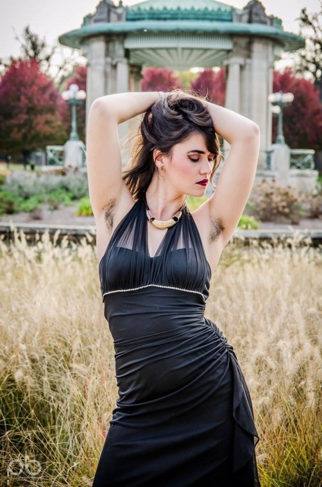 Woman with underarm hair in a black dress.