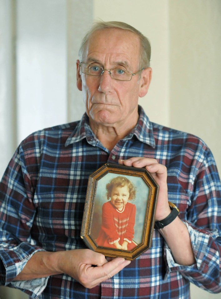 A man holding a photo of his daughter who disappeared from a supermarket in Germany in 1981.