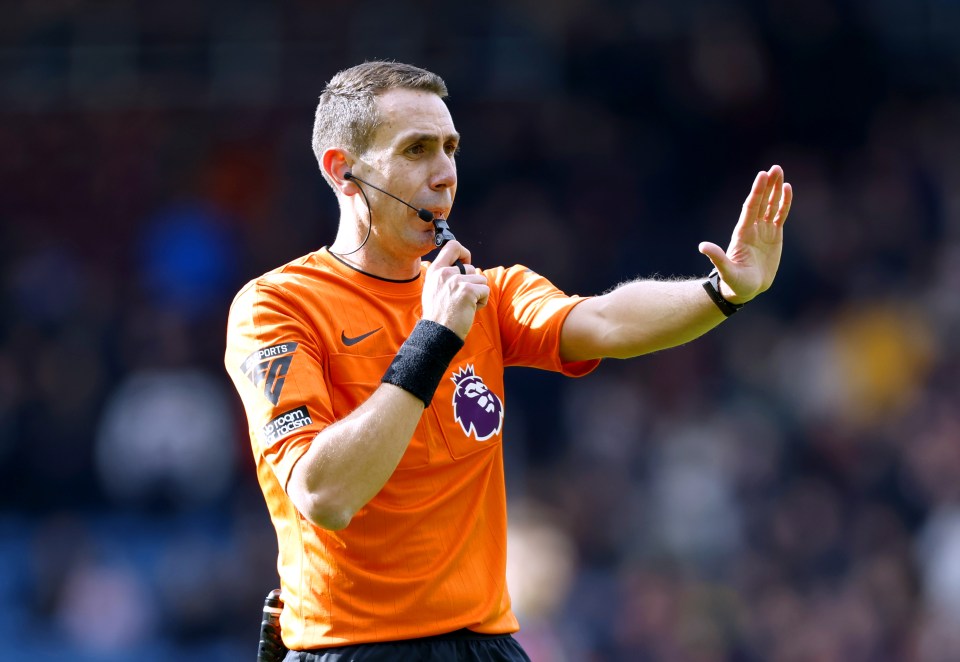 Referee David Coote signaling during a soccer match.