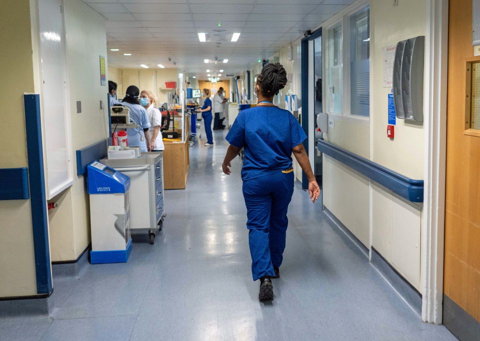 A nurse walks down a hospital hallway.