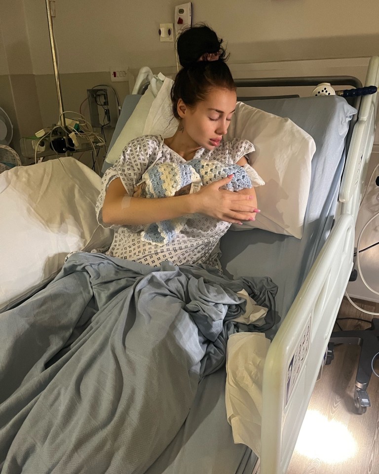 Woman in hospital bed holding newborn baby.