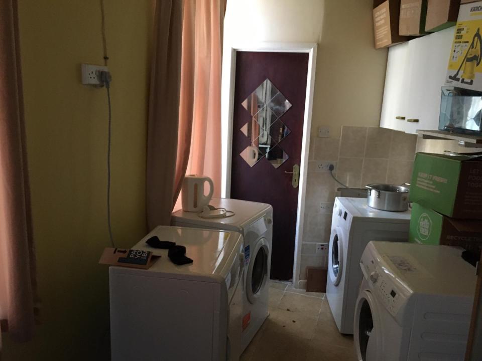 Utility room with washing machines and a kettle.