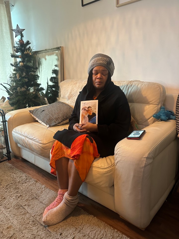 A grieving mother holds a photo of her deceased son.